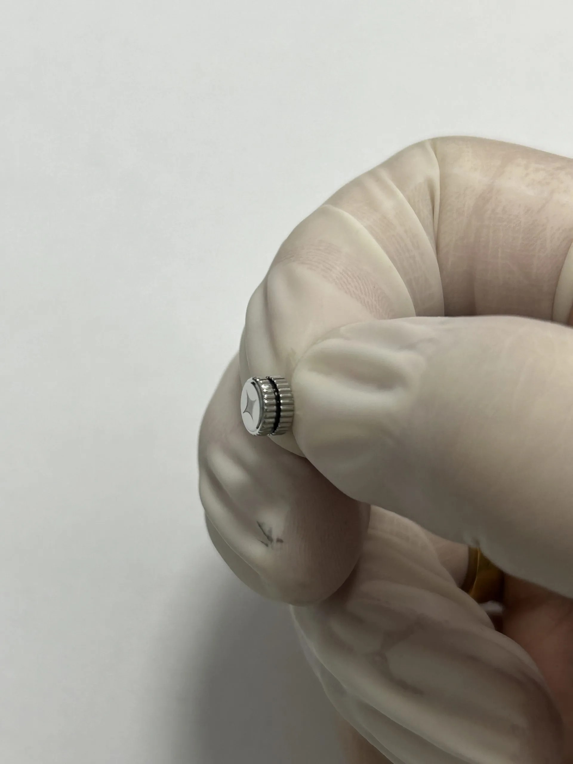 Crown held in gloved hand - offset at 4 o'clock
